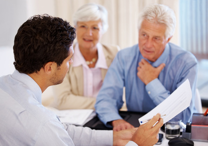 Discussing investment plans - Senior client with agent holding an agreement paper